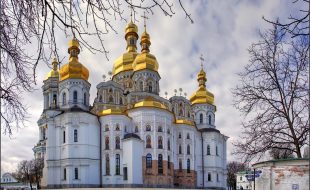 Ławra Peczerska w Kijowie, zdjęcie, biały budynek ze złotymi kopułami i ikonami we wnękach murów
